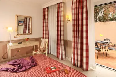 a bedroom with a bed and a desk and a table at Hotel Villa Glori in Rome