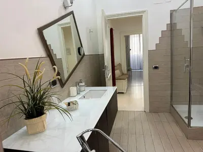 a bathroom with a sink and a mirror and a shower at Rome Holiday Home in Rome