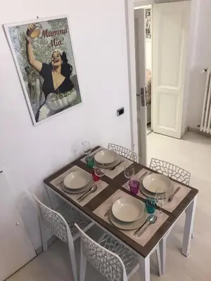 a dining room table with chairs and a poster of a woman at Rome Holiday Home in Rome