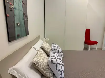 a couch with pillows on it with a red chair at Rome Holiday Home in Rome