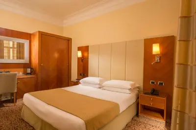 a hotel room with a large bed and a table at Suite Opera Rooms in Rome