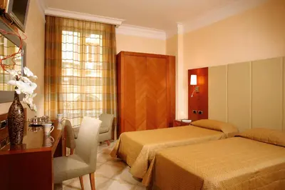 a hotel room with two beds and a table at Suite Opera Rooms in Rome