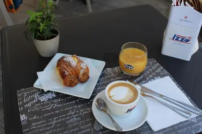 a table topped with a cup of coffee and a pastry at Suite Opera Rooms in Rome