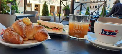 a table with a sandwich and a glass of beer at Suite Opera Rooms in Rome