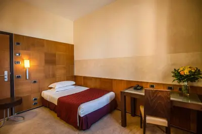 a hotel room with a bed and a desk and a table at Kolbe Hotel Rome in Rome
