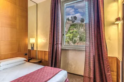 a bedroom with a bed and a window with curtains at Kolbe Hotel Rome in Rome