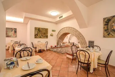 a restaurant with tables and chairs in a room at Hotel Corona in Rome
