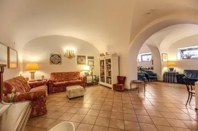 a large living room with couches and chairs at Hotel Corona in Rome