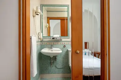 a bathroom with a sink and a mirror at Hotel Emona Aquaeductus in Rome