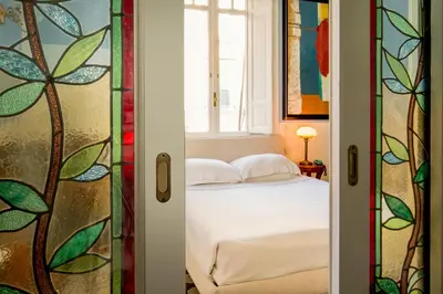 a bedroom with a bed through a glass door at Hotel Emona Aquaeductus in Rome
