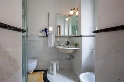 a bathroom with a sink and a toilet and a mirror at Hotel Emona Aquaeductus in Rome