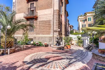 a courtyard with a fountain in front of a building at Hotel Emona Aquaeductus in Rome