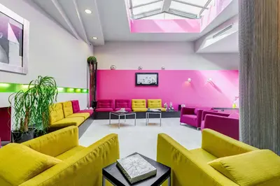 a room with yellow and pink chairs and tables at Best Western Cinemusic Hotel in Rome