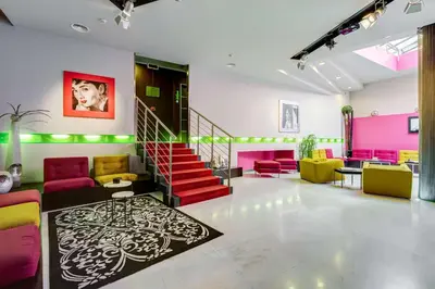 a lobby with pink and yellow furniture and a staircase at Best Western Cinemusic Hotel in Rome