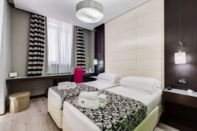 a hotel room with two beds and a bathroom at Best Western Cinemusic Hotel in Rome