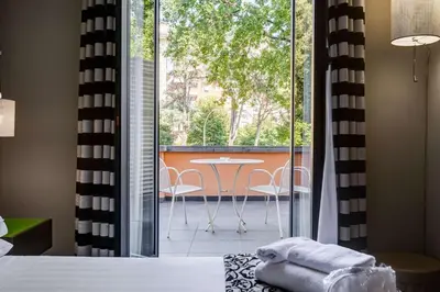 a bedroom with a view of a balcony with a table and chairs at Best Western Cinemusic Hotel in Rome