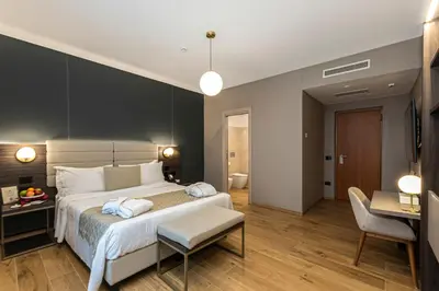 a bedroom with a large bed and a living room at Hotel San Remo in Rome