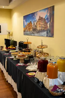a long table with food and drinks on it at Hotel San Remo in Rome