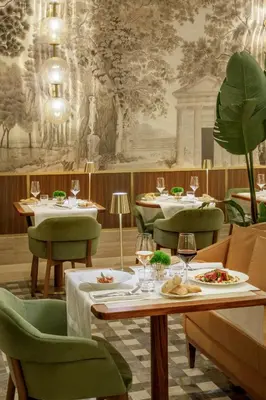 a table with plates of food and wine glasses at Hotel Imperiale by OMNIA hotels in Rome