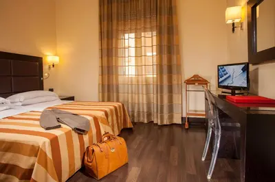a hotel room with two beds and a television at Hotel Buenos Aires in Rome