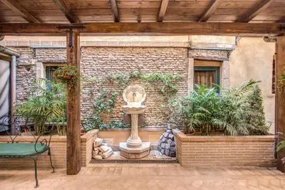 a fountain in front of a brick wall with plants at Residenza San Calisto in Rome