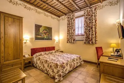 a hotel room with a bed and a desk and a window at Residenza San Calisto in Rome