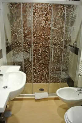 a bathroom with a shower and two sinks and a toilet at Hotel Dei Mille in Rome