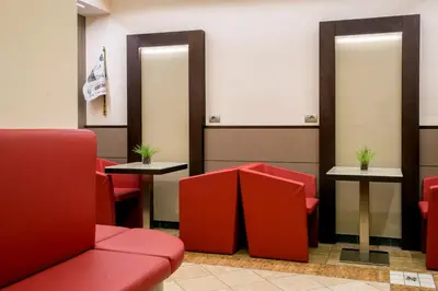 a waiting room with red chairs and mirrors at Hotel Dei Mille in Rome