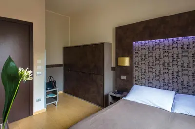 a bedroom with a large bed with a large headboard at Hotel Dei Mille in Rome