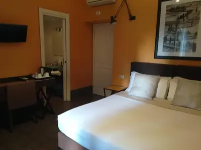 a bedroom with a large white bed and a desk at Locanda degli Antiquari in Rome