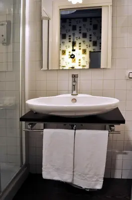 a bathroom with a sink and a mirror and towels at Locanda degli Antiquari in Rome