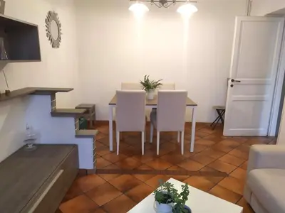 a living room with a table and white chairs at Testaccio comodo appartamento in Rome
