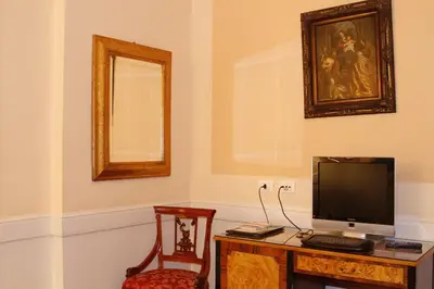 a room with a desk with a television and a chair at Boutique Hotel Trevi in Rome