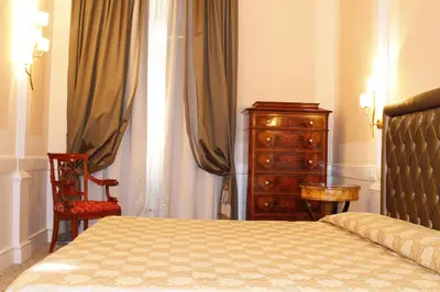 a bedroom with a bed and a dresser and a chair at Boutique Hotel Trevi in Rome