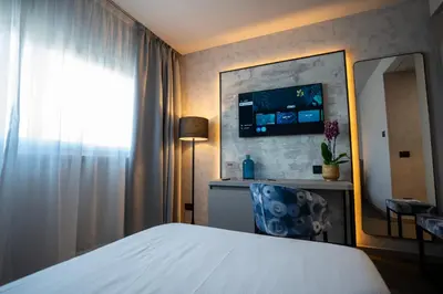 a hotel room with a bed and a desk with a laptop at BV Hotel Oly in Rome