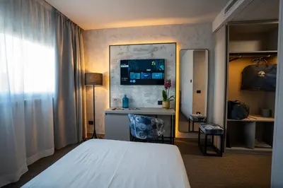 a hotel room with two beds and a desk at BV Hotel Oly in Rome