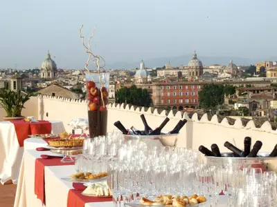 a table with food and wine glasses and a view of a city at Donna Camilla Savelli - VRetreats in Rome
