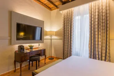 a bedroom with a bed and a desk and a television at Donna Camilla Savelli - VRetreats in Rome