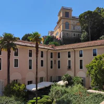 a large building with palm trees in front of it at Donna Camilla Savelli - VRetreats in Rome