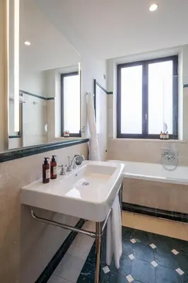 a white bathroom with a sink and a tub at Donna Camilla Savelli - VRetreats in Rome