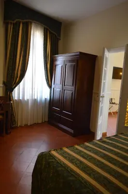 a bedroom with a bed and a dresser and a window at Pantheon Inn in Rome