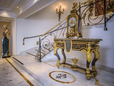 a gold clock in a room with a staircase at Rome Cavalieri, A Waldorf Astoria Hotel in Rome