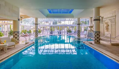 a swimming pool in a hotel with a large building at Rome Cavalieri, A Waldorf Astoria Hotel in Rome