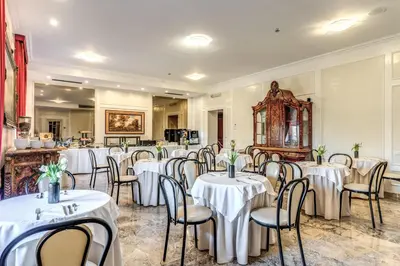 a room filled with tables and chairs with white tablecloths at Hotel Orazia in Rome