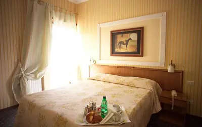 a hotel room with a bed with a tray with drinks on it at Hotel Residence Magnolia in Rome