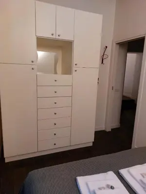a white closet with white cabinets and a table at EasyInRome Navona in Rome