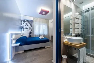 a bedroom with a bed and a sink and a tub at Il Rosso e il Blu in Rome