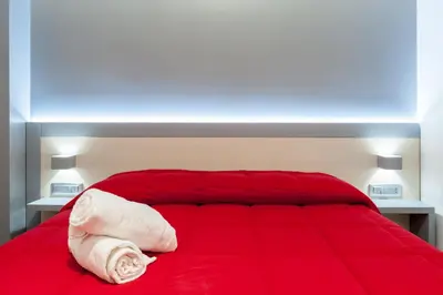 a bedroom with a red bed with a red blanket at Il Rosso e il Blu in Rome