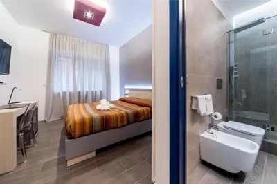 a bathroom with a bed and a sink and a toilet at Il Rosso e il Blu in Rome