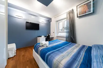 a blue bedroom with a bed and a tv at Il Rosso e il Blu in Rome